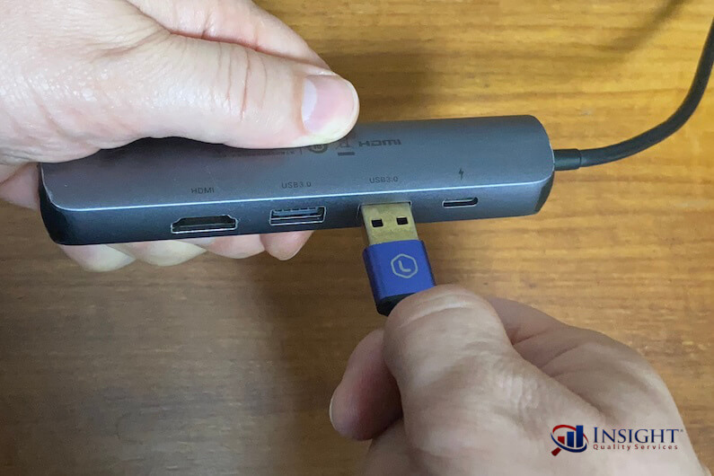 Hands plugging USB cable into USB hub