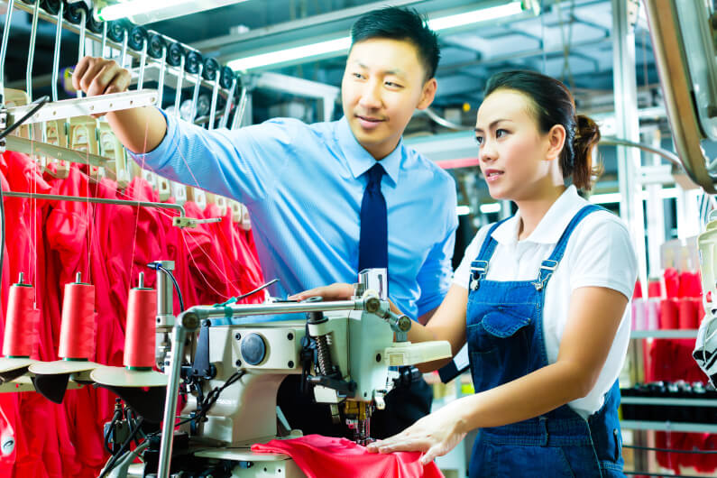 Foreman explaining something to a seamstress
