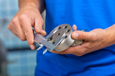 Calipers are quality control tool being used here to measure a metal part