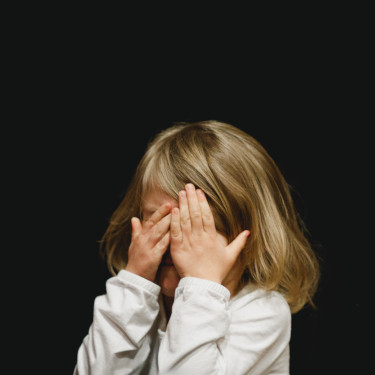 Little girl covering her eyes