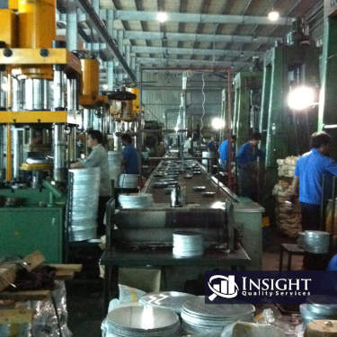 The inside of a factory stamping metal bowls