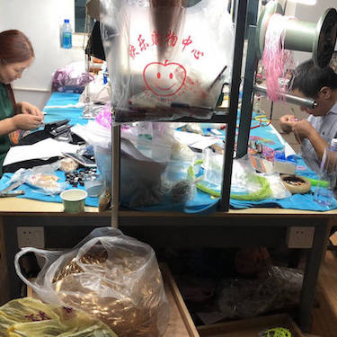 Two factory workers at a table, working