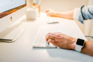 Man typing on computer at desk